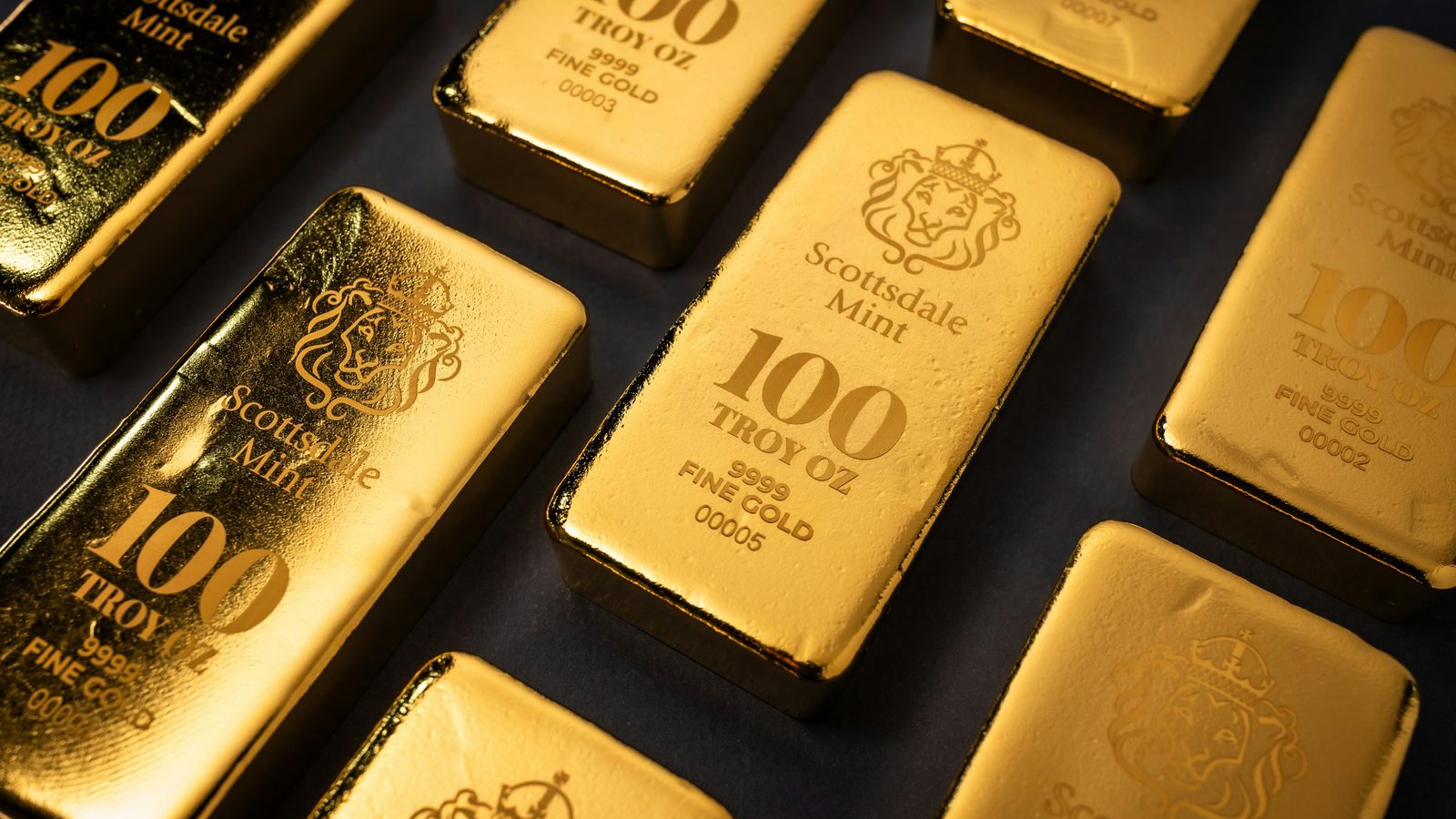 Rows of Scottsdale Mint 100-troy-ounce gold bars stamped 9999 fine gold