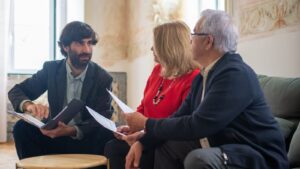 Retired couple reviewing documents with a financial advisor in an elegant sitting room
